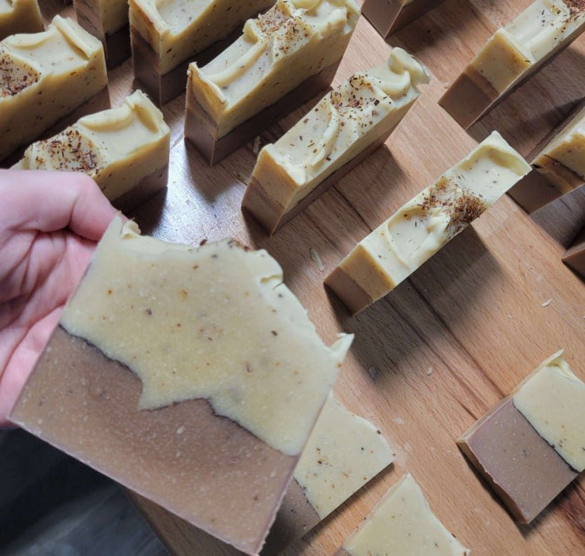 a person cutting a piece of bread with a knife 